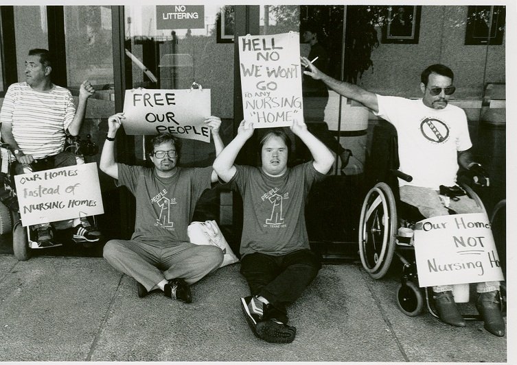 adult protesters holding posters black white photograph disability history america 