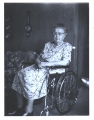 An elderly woman sitting at home in her wheelchair
