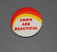 A white, orange, and yellow button with the words “Crips are Beautiful”,